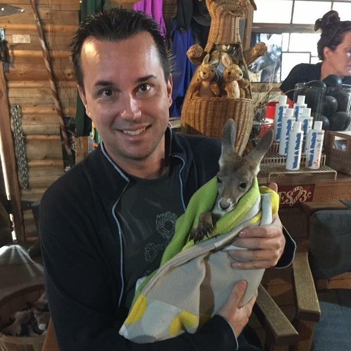 Man holding a small kangaroo wrapped in a towel