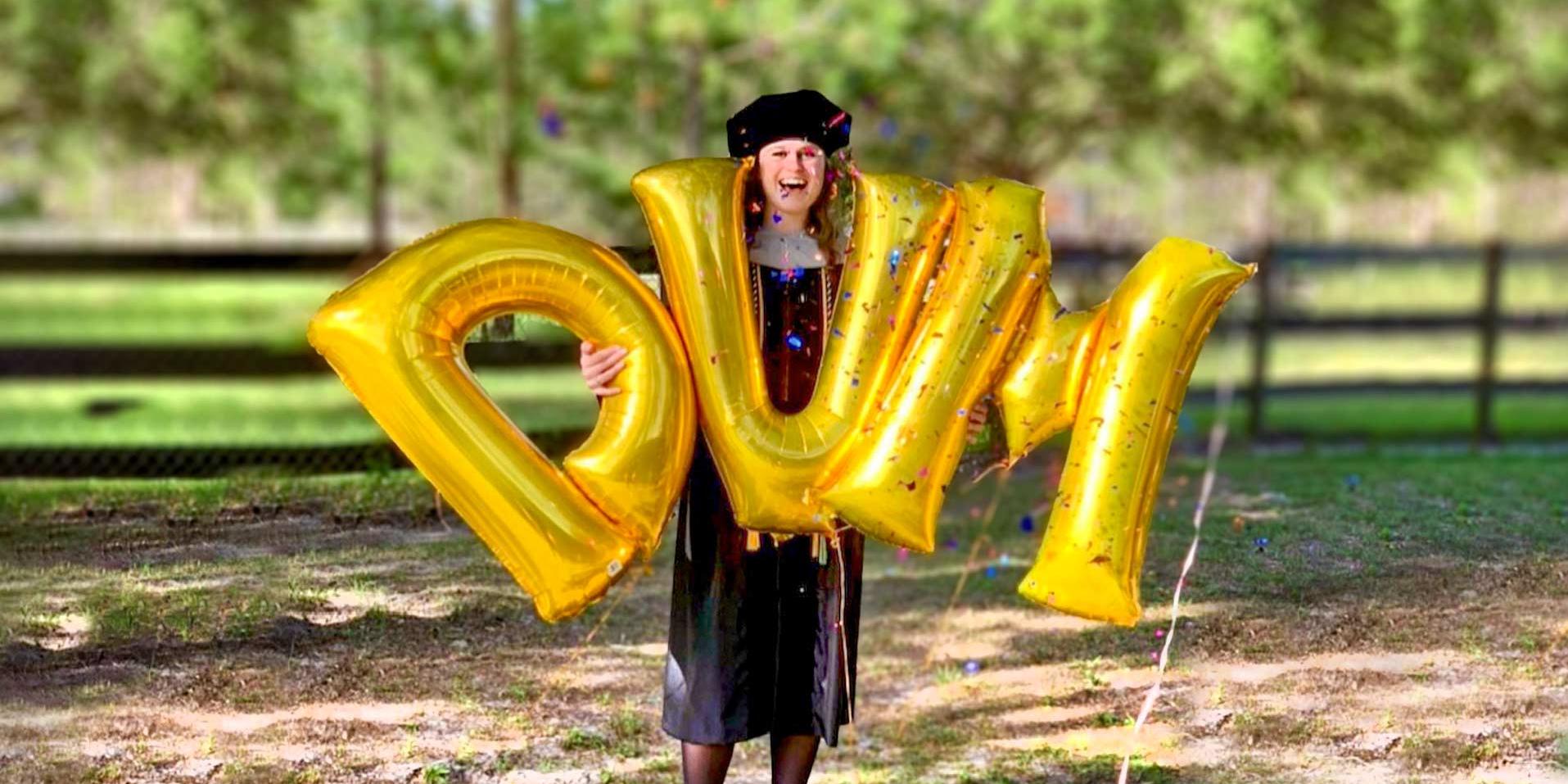 Graduate Celebrating with DVM balloons
