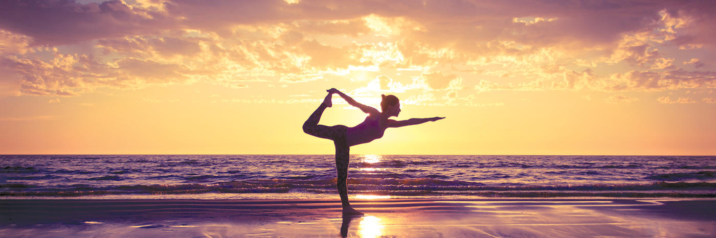 A person does yoga by the beach