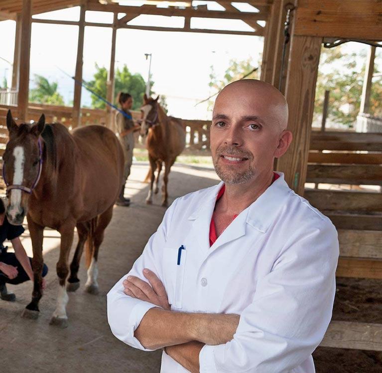 Veterinarian posing next to a horse