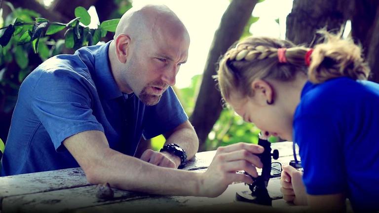 Teacher and student using a microscope