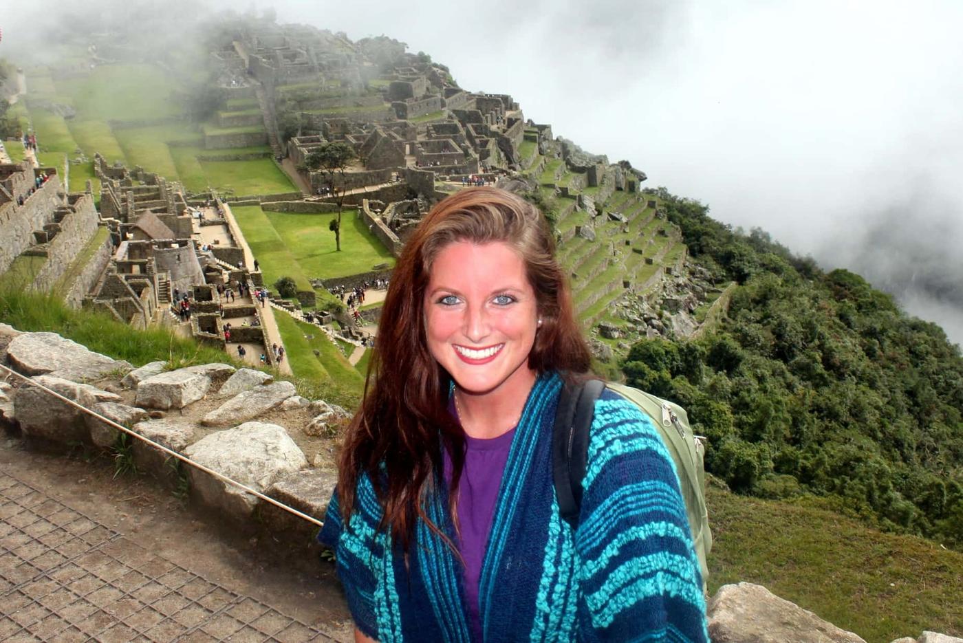 Veterinary student smiling in front of view of Peru