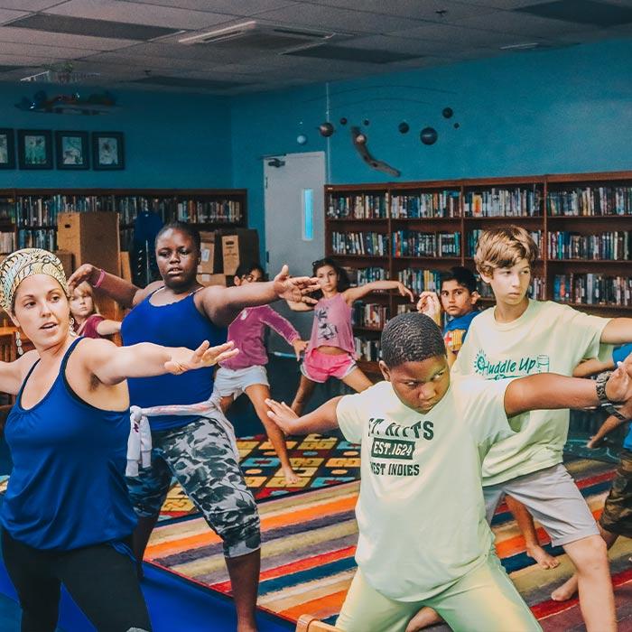 A teacher and her students practicing yoga