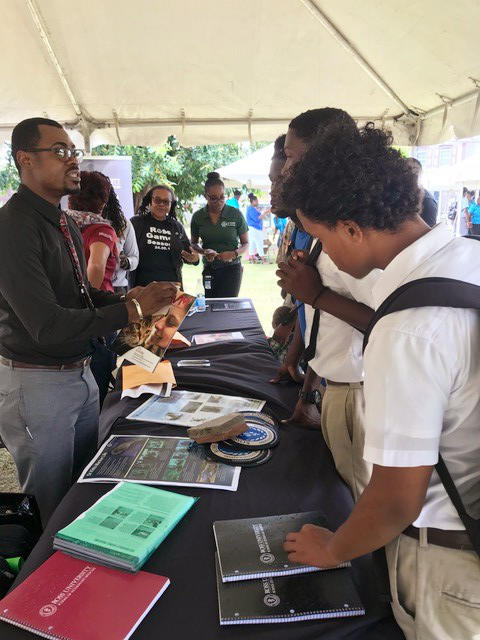 Students speaking to a representative at a table booth.