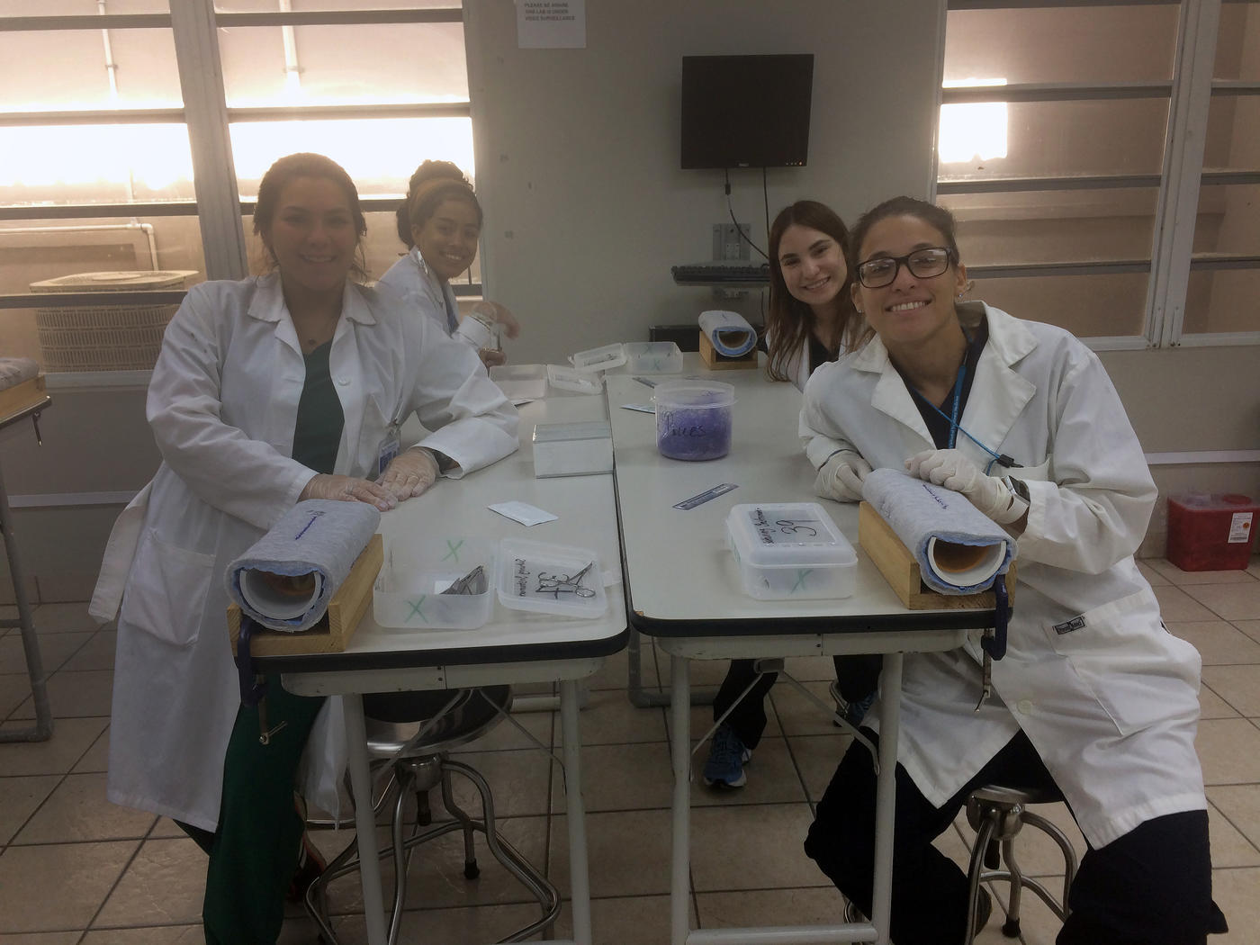 Students in lab coats working at a table